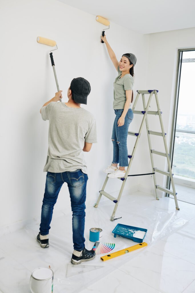 Professional painter applying a fresh coat of paint to a living room wall.