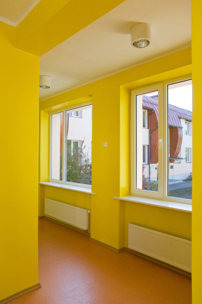 A professional painter applying a fresh coat of paint to an indoor wall.